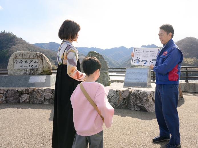 ▲まずは記念碑広場で、国土交通省ダム職員からダムの概要説明を聞きます。